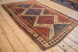 Fine antique Hamadan rug viewed at an angle, displaying its geometric medallions in rich, earthy tones.