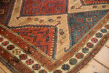 Intricate stepped contours and arrowed finials at the corner of an antique Persian Hamadan rug.
