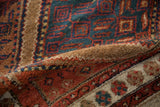 A folded section of the antique Hamadan rug reveals its dense, even pile and original selvage.