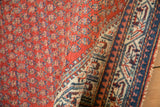 Rolled Vintage Serbend rug featuring cherry red boteh field and ivory pawn motif border.