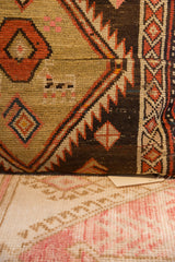 Detail of Vintage Rug Fragment Pillow's hand-knotted dark brown, rust, and cream tribal pattern.