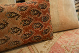Close-up of the hand-knotted texture and warm terracotta abrash on the Malayer rug pillow.