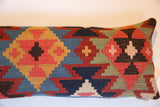 Handmade vintage Kilim pillow fragment showcasing stepped geometric motifs in blue, red, gold.