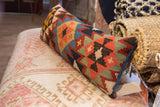 Detail of the colorful geometric pattern and blue piping on a vintage Kilim pillow.