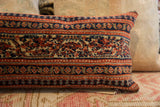 Vintage Persian hand-knotted pillow detail; terracotta, dark blue, and beige geometric motifs.