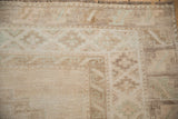 Distressed Kars carpet close-up showing muted geometric patterns on abrashes pile and fringe.