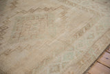 Distressed Kars carpet pile showcasing faded geometric patterns in muted beige and pale green.