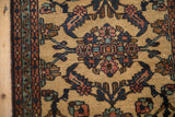 Corner detail of a vintage Mehriban rug showing its meandering vine border and primitive floral blossoms.