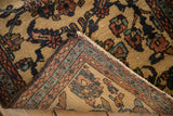 A folded corner on the vintage Mehriban rug reveals its hand-knotted back and floral pile.