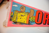 Angled detail of the cartoon beaver holding a map on the vintage Oregon pennant.