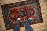 Vintage Tajabad rug shown for scale, with a geometric medallion in rust, sapphire blue, and navy.