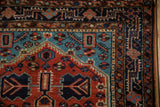 The navy blue Josan main border and pinwheel floral corner of a hand-knotted Tajabad rug.