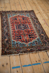 Angled view of the vintage Tajabad rug's geometric medallion in rust, sapphire, and navy blue.