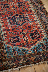 Angled view of the vintage Tajabad rug's even pile, showing the rust and blue Josan border.