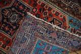 Detail of a vintage Persian rug's folded corner, highlighting the hand-knotted weave and rich pile.