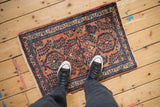Hand-knotted vintage Lilihan rug with terracotta and sapphire blue stylized millefleur floral sprays.
