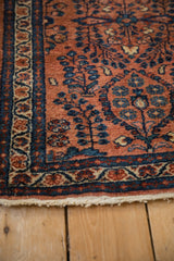 Detail of the Lilihan rug's terracotta field with sapphire blue millefleur and ivory fringe.