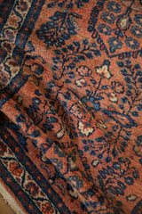 Intricate sapphire blue floral pattern on the terracotta, folded pile of a Lilihan rug.