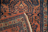 Lilihan rug corner with terracotta field, sapphire millefleur design, and intact side cord.