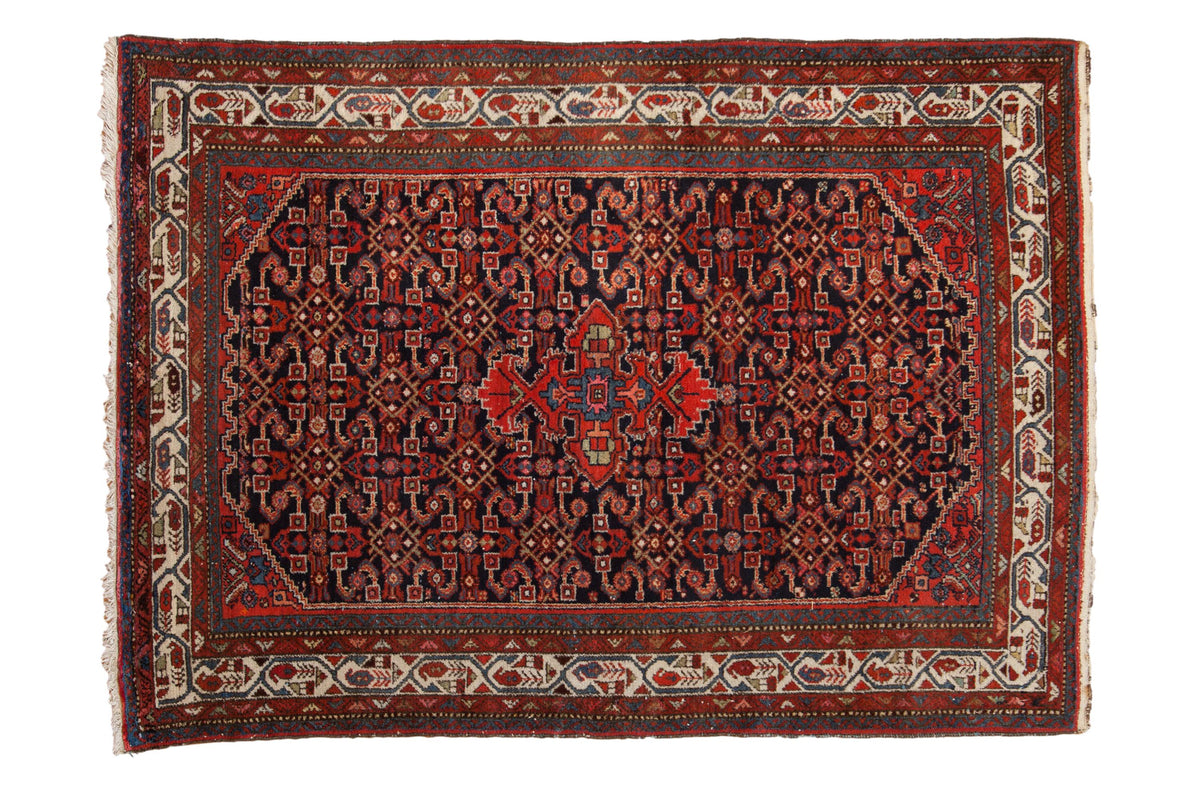 Vintage Hamadan rug with a shield-like center medallion over a navy blue field with a dense Herati design.
