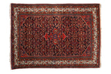 Vintage Hamadan rug with a shield-like center medallion over a navy blue field with a dense Herati design.