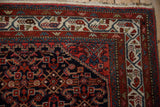 Intricate ivory, red, and dusty blue borders frame the navy blue Herati field of a vintage Persian Hamadan rug.