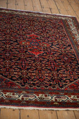 Low angle view of the red medallion and navy Herati pattern on a vintage Persian Hamadan rug.
