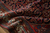 Close-up of the hand-knotted wool pile and navy Herati pattern on a vintage Persian Hamadan rug.