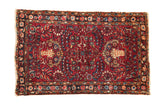 Vintage Persian Lilihan rug with a shadow medallion and floral sprays on a pomegranate red field.