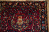 Detail of a vintage Lilihan rug's low pile, floral border, and frayed side finish.