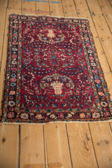 Angled view of a red vintage Lilihan rug with blossomed planters and delicate floral sprays.