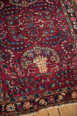 An inwardly directed Tree of Life planter motif on the red field of a vintage Lilihan rug.