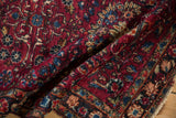 Detailed texture of a vintage Lilihan rug with pomegranate red and sapphire blue floral designs.