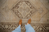 Textural view of distressed Oushak rug showing worn pile and coffee brown diamond patterns.