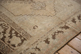 Heavily abraded vintage Oushak carpet showing worn brown patterns and exposed foundation.