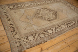 Distressed Oushak rug's coffee brown patterns, ivory field, and visible foundation.