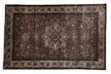 Antique silk Kashan collector rug with an intricate floral medallion in deep violet, blue, and gold.