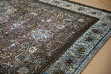 Fine weave and articulated texture of violet and blue floral motifs on an antique silk rug.