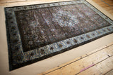 Deep purple and blue tones of a collector's antique silk Kashan rug viewed from an angle.