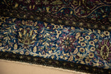 Intricate border detail of a fine silk Kashan with recessed jewel tones and raised pile texture.