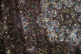 The velvety, recessed pile of an antique silk rug showing its dark violet and blue tones.