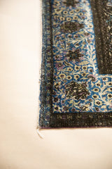 Detail of the original purple silk selvage on an antique Kashan rug's floral border.