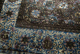 Tactile relief of raised brown pile against recessed blue and violet silk on an antique Kashan rug.