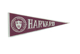 Vintage Harvard felt pennant in maroon and white, with academic seal and bold text.