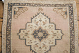 Floral medallion detail of a vintage Oushak rug in dusty rose, ivory, and dusty teal.