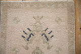 Distressed hand-knotted texture of a vintage Oushak rug with a dusty navy blue floral detail.