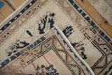 A folded corner of a vintage Oushak rug highlights its low-pile texture and machine-bound edge.