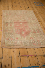 Distressed vintage Oushak rug corner showing worn pile, exposed foundation, geometric motifs, and fringe.