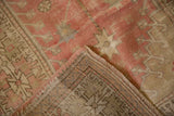 Worn texture and foundation of a distressed Oushak rug with muted pink geometric patterns.