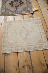 Faded cream and dusty rose distressed Oushak square rug with geometric medallion.